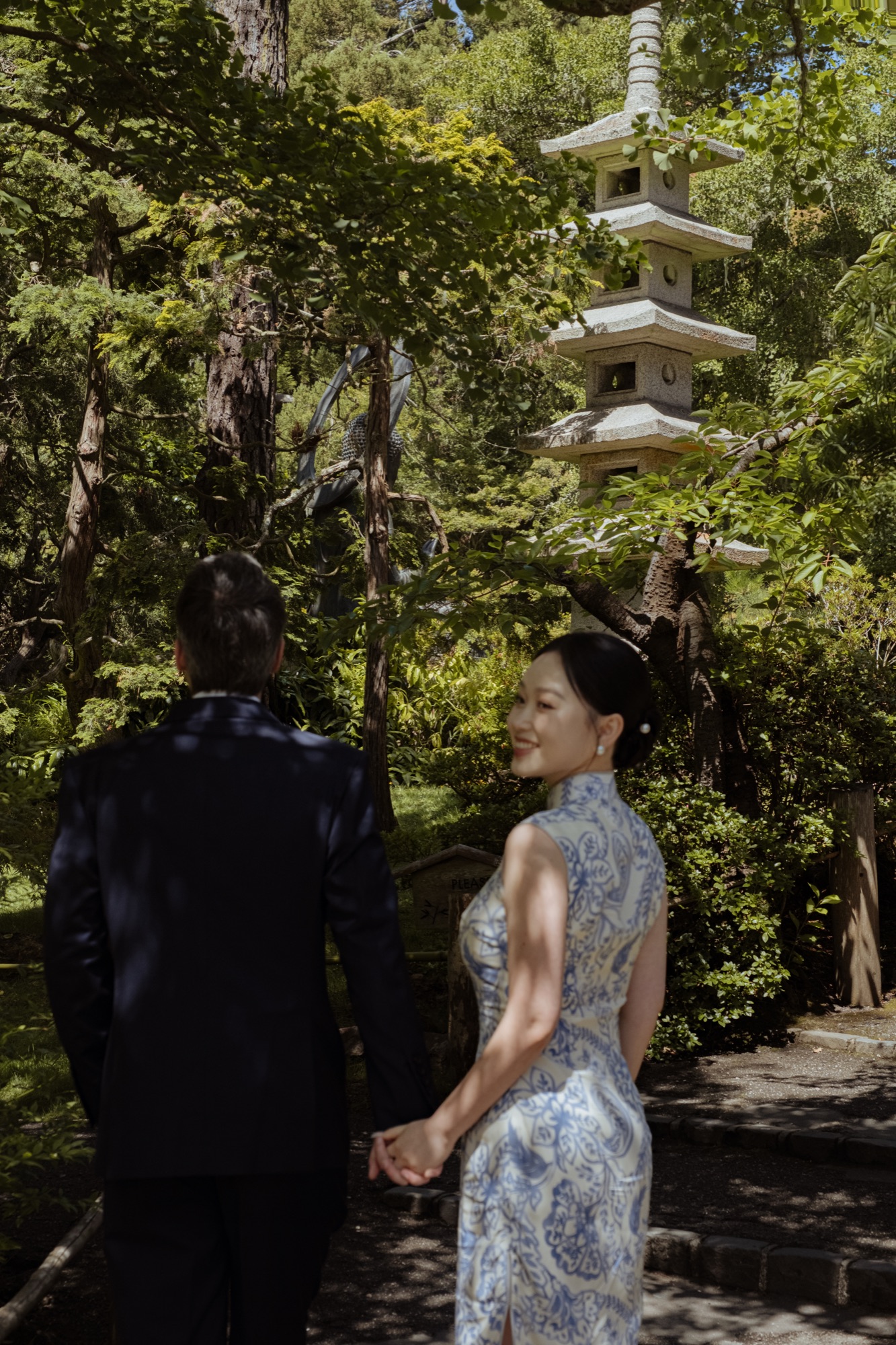 The couple standing beneath green trees in the Japanese Tea Garden