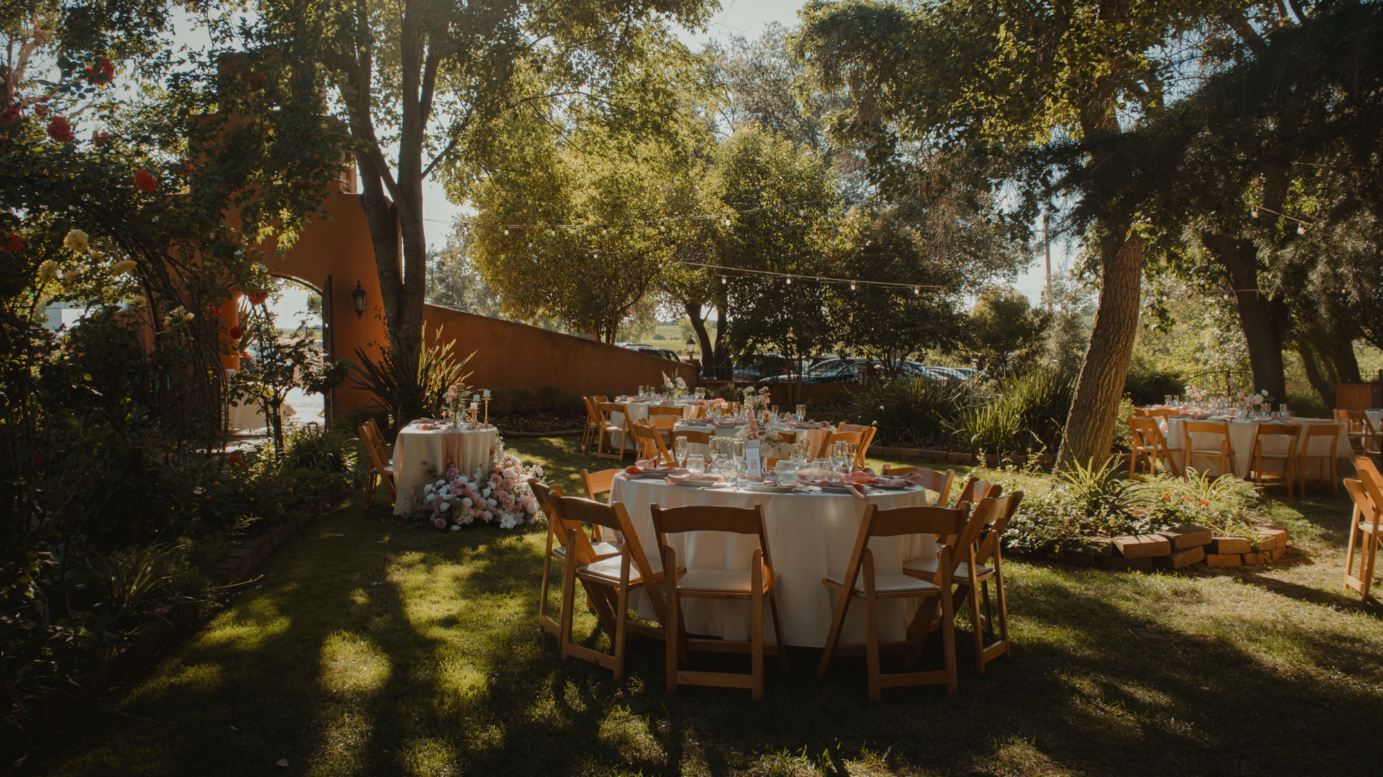 The outdoor reception tables waiting beneath the trees